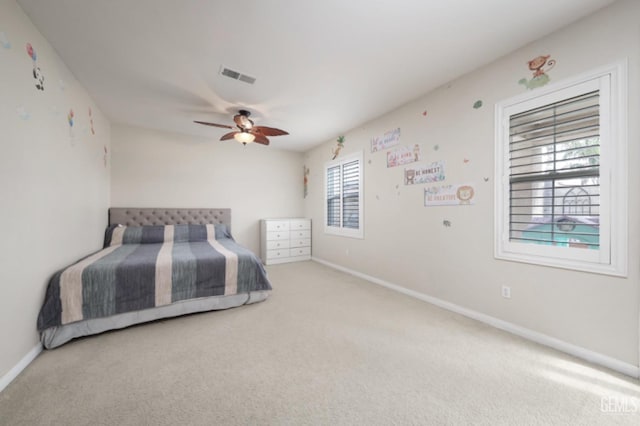 carpeted bedroom featuring a ceiling fan, visible vents, and baseboards