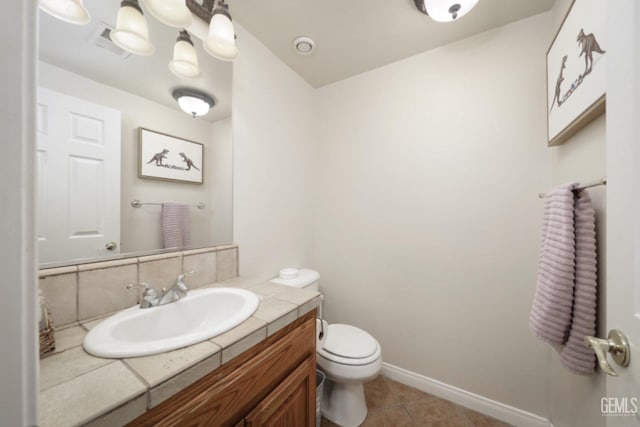 bathroom with visible vents, baseboards, toilet, tile patterned floors, and vanity