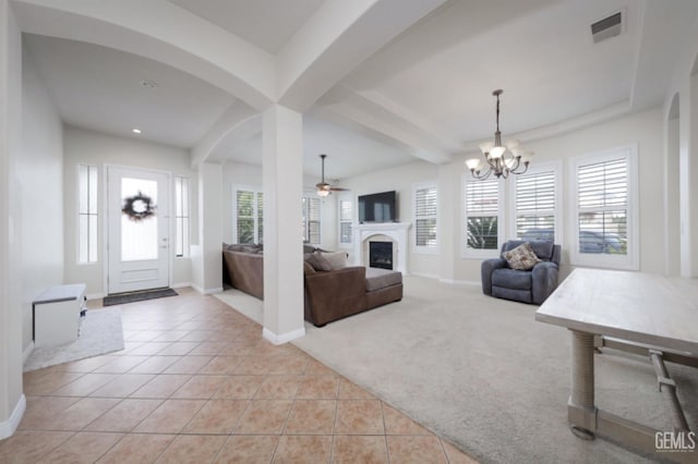 foyer featuring light tile patterned floors, plenty of natural light, a fireplace, and light colored carpet