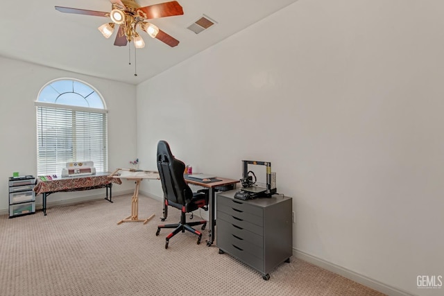 office area with baseboards, visible vents, ceiling fan, and light colored carpet