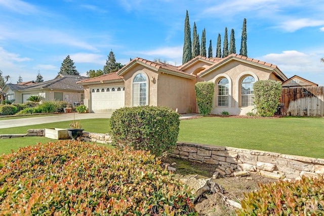 mediterranean / spanish house with an attached garage, fence, driveway, stucco siding, and a front yard