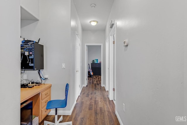 hall with dark wood-style floors and baseboards