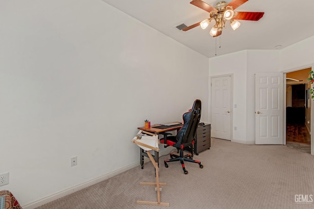 office area with light carpet, a ceiling fan, visible vents, and baseboards