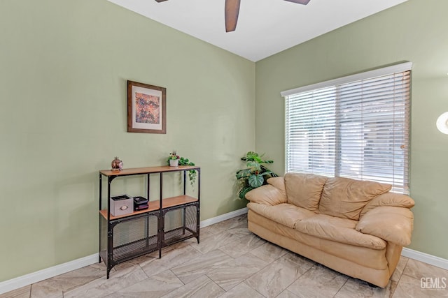 sitting room with ceiling fan and baseboards