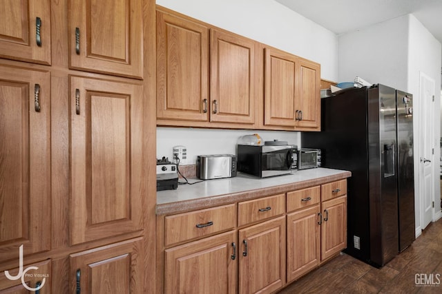 kitchen featuring black fridge with ice dispenser and dark hardwood / wood-style floors