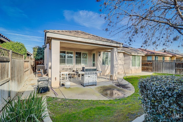 rear view of property featuring a patio and a lawn