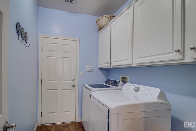 laundry room with dark hardwood / wood-style floors, cabinets, and washing machine and clothes dryer