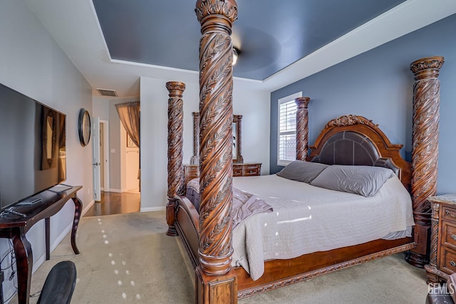 bedroom with light carpet and a tray ceiling