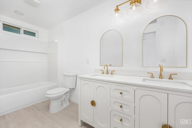 full bathroom featuring vanity, hardwood / wood-style flooring, bathtub / shower combination, and toilet