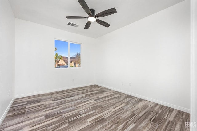 empty room with hardwood / wood-style floors and ceiling fan