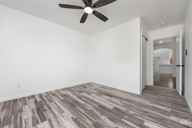 empty room with hardwood / wood-style flooring and ceiling fan