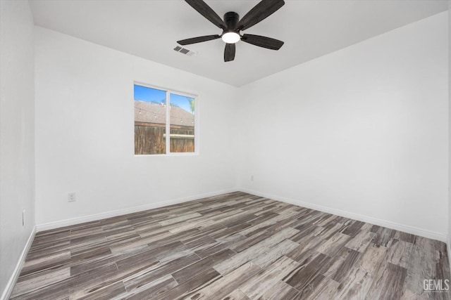 empty room with dark hardwood / wood-style floors and ceiling fan