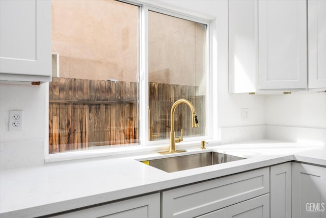 room details featuring light stone counters and sink