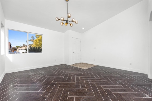 spare room with an inviting chandelier and dark parquet flooring