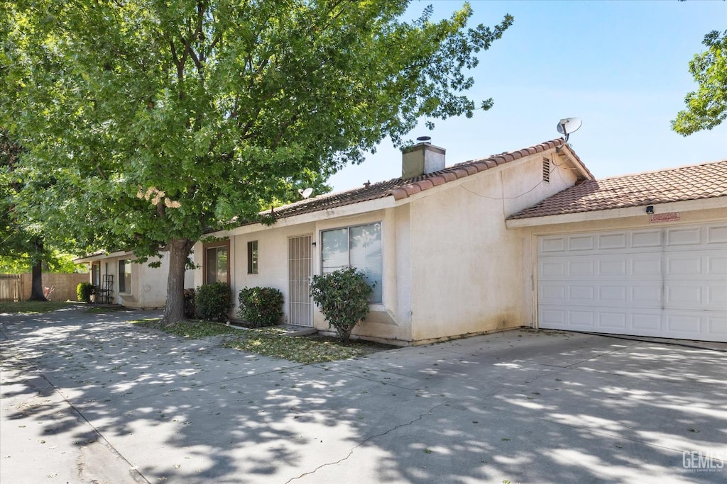 2726 Gosford Rd, Bakersfield, CA 93309 - single story home with a chimney, concrete driveway, a tile roof, and stucco siding