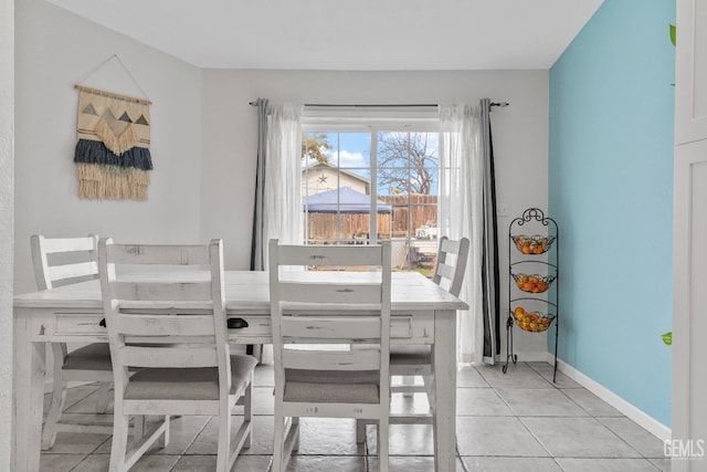 dining room featuring baseboards and light tile patterned floors