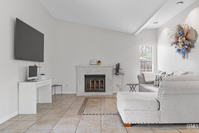 living area featuring vaulted ceiling with beams, light tile patterned floors, a brick fireplace, and baseboards