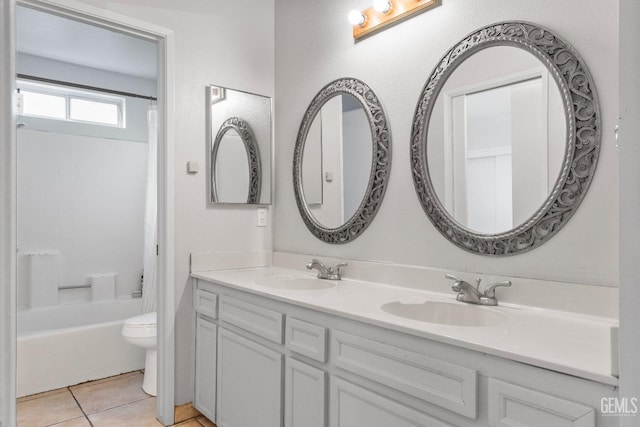 full bath with toilet, tile patterned flooring, double vanity, and a sink