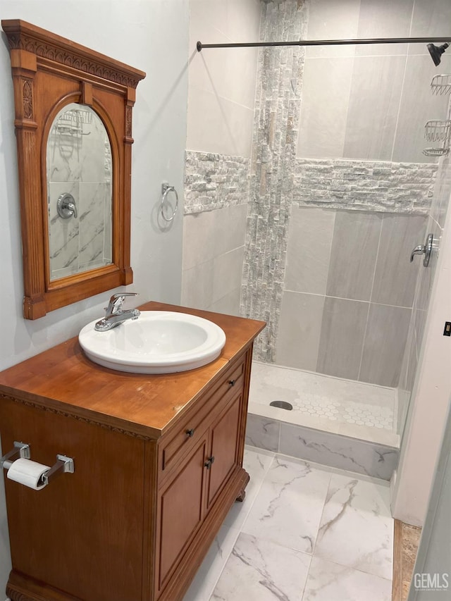 bathroom with marble finish floor, a shower stall, and vanity