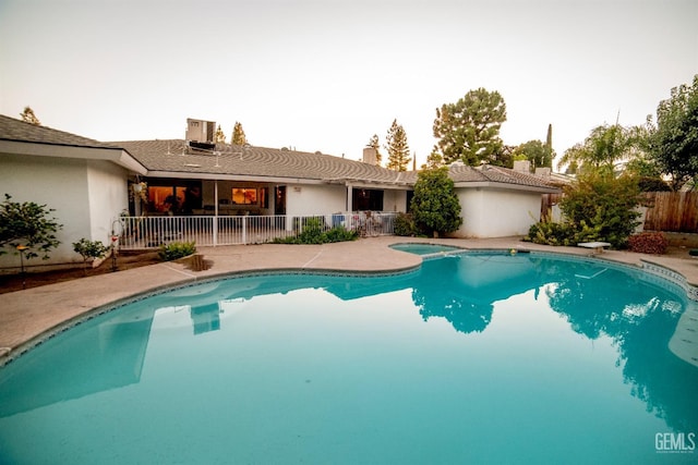 view of swimming pool with a diving board