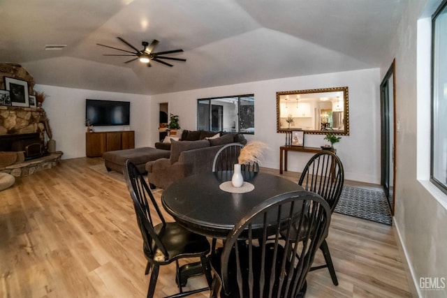 dining area featuring ceiling fan, light wood-type flooring, and vaulted ceiling