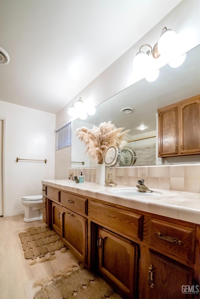 bathroom featuring hardwood / wood-style floors, vanity, and toilet