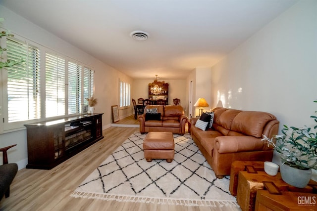 living room featuring light hardwood / wood-style floors and a notable chandelier