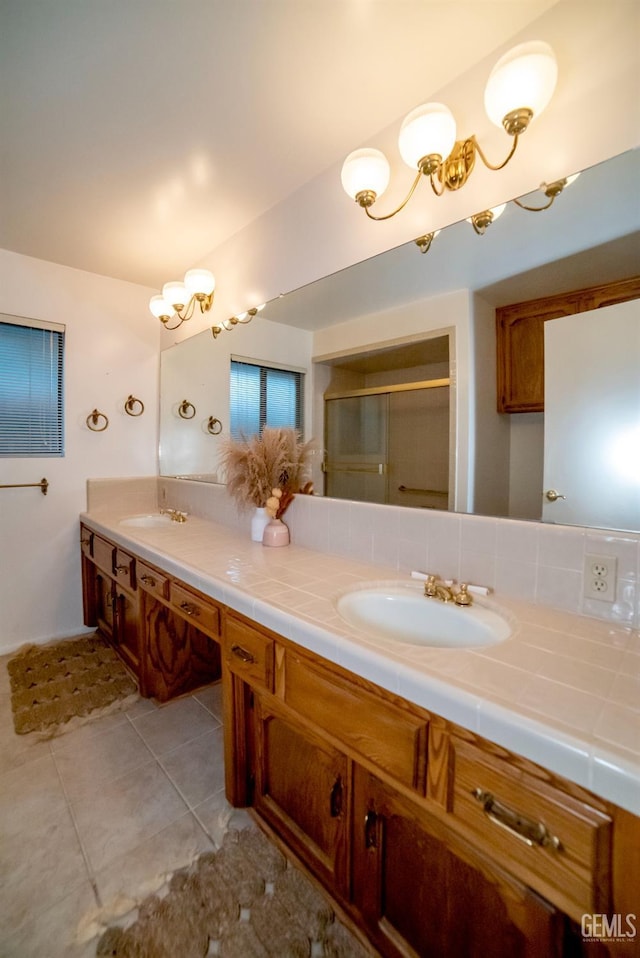 bathroom featuring tile patterned floors, vanity, and a shower with shower door