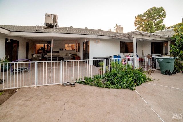 rear view of house with an outdoor living space, central air condition unit, a patio, and a pergola