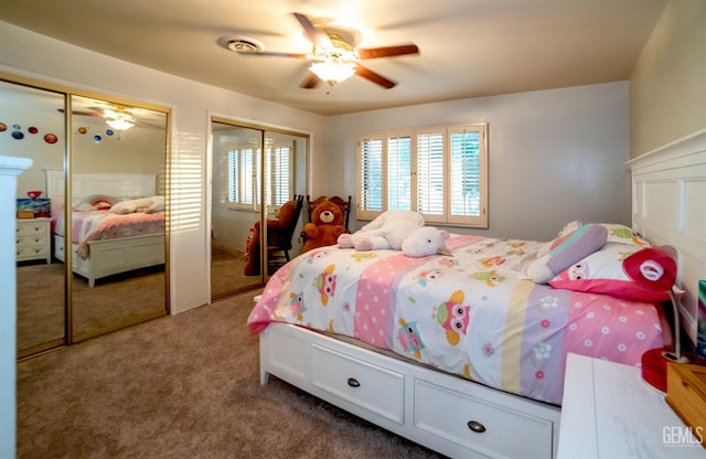 bedroom with carpet flooring, ceiling fan, and two closets