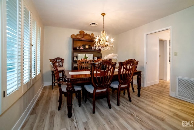 dining room with a notable chandelier and light wood-type flooring