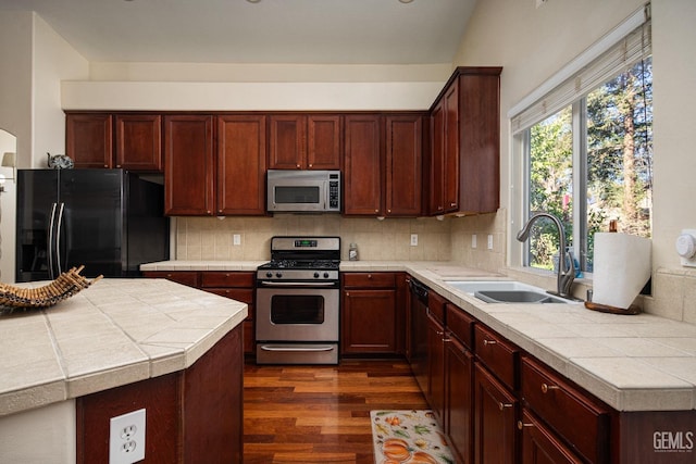 kitchen with sink, backsplash, tile counters, and black appliances