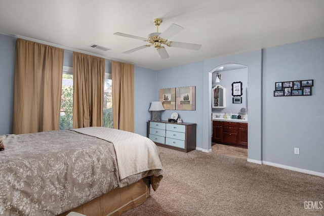 carpeted bedroom with ceiling fan and ensuite bath