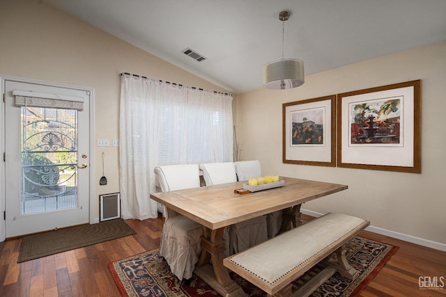 dining room featuring dark wood-type flooring and lofted ceiling