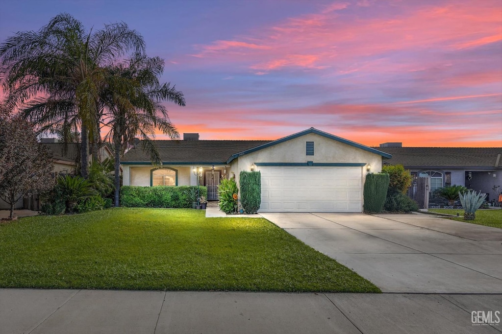 ranch-style house featuring a yard and a garage