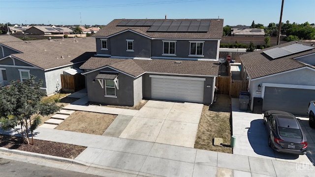 5910 Bogart Dr, Bakersfield, CA 93313 - traditional-style home with stucco siding, driveway, roof mounted solar panels, a shingled roof, and an attached garage