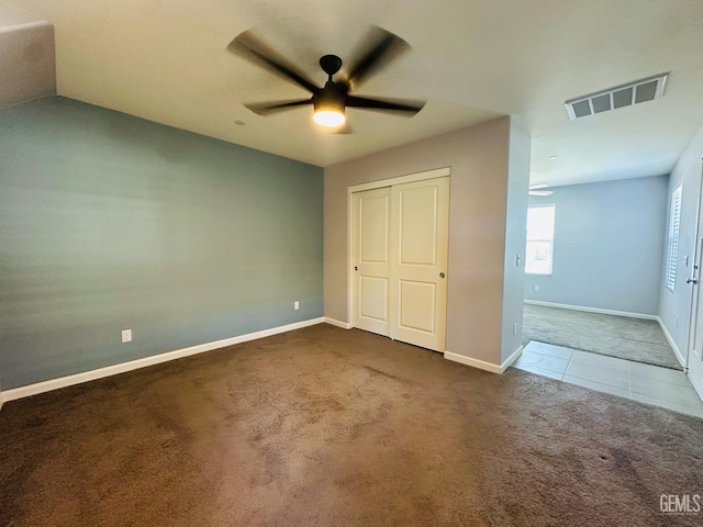 5910 Bogart Dr, Bakersfield, CA 93313 - unfurnished bedroom featuring carpet floors, tile patterned floors, a ceiling fan, and a closet