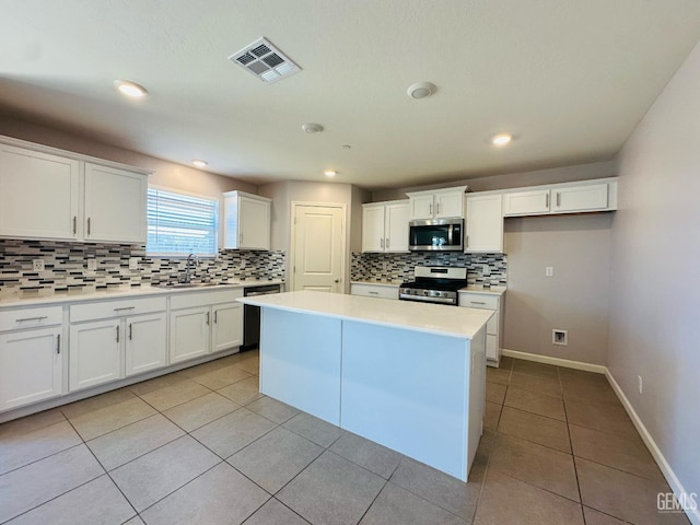 5910 Bogart Dr, Bakersfield, CA 93313 - kitchen featuring appliances with stainless steel finishes, tasteful backsplash, light tile patterned floors, white cabinets, and light countertops