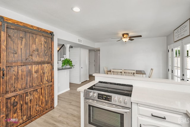11265 Poulsen Way, Bakersfield, CA 93312 - kitchen with electric stove, a ceiling fan, white cabinets, light countertops, and light wood-style flooring