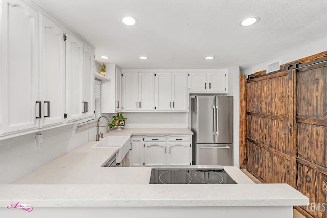11265 Poulsen Way, Bakersfield, CA 93312 - kitchen with freestanding refrigerator, recessed lighting, white cabinets, and black electric stovetop