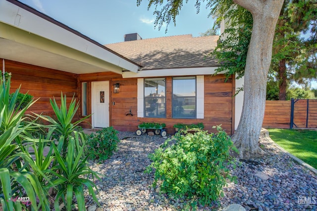 11265 Poulsen Way, Bakersfield, CA 93312 - view of exterior entry featuring a shingled roof and a chimney