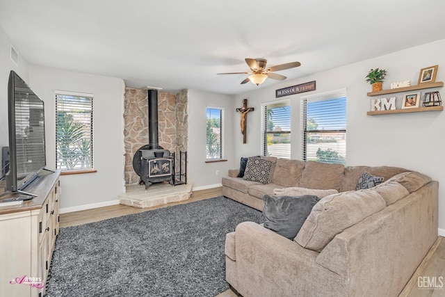 11265 Poulsen Way, Bakersfield, CA 93312 - living area featuring wood finished floors, plenty of natural light, a ceiling fan, and a wood stove