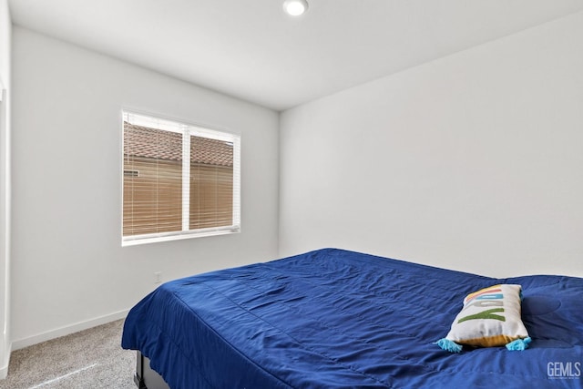 bedroom with baseboards and carpet