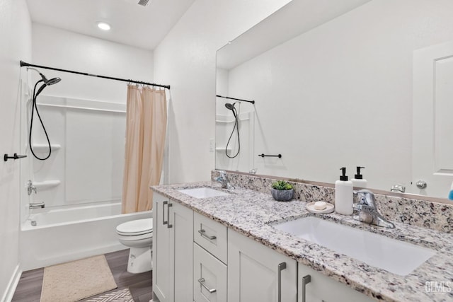 full bathroom featuring a sink, shower / bath combo with shower curtain, toilet, and wood finished floors