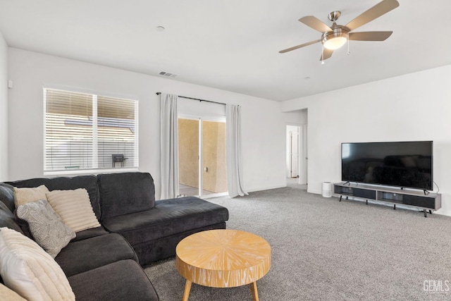 living area with visible vents, baseboards, ceiling fan, and carpet flooring