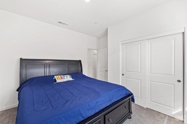 bedroom featuring a closet, baseboards, visible vents, and carpet floors