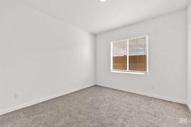 spare room with baseboards and carpet