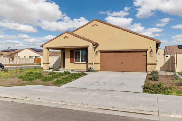 view of front facade featuring stucco siding, an attached garage, concrete driveway, and fence