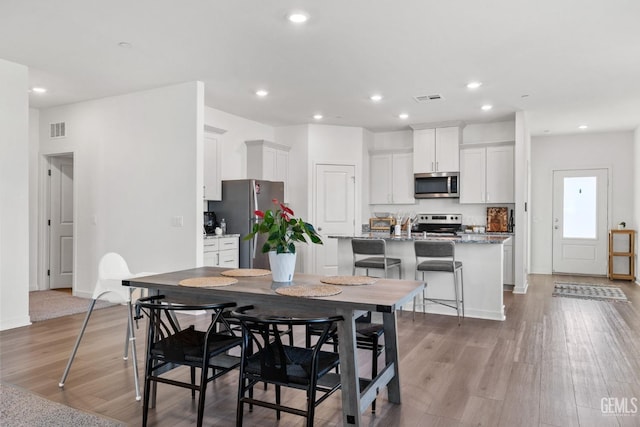 dining space with visible vents, recessed lighting, and light wood-type flooring