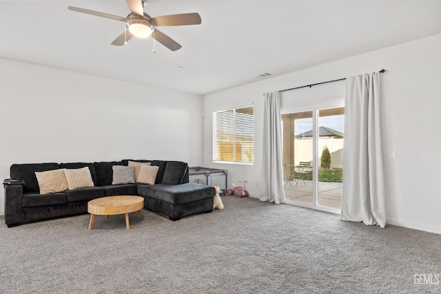 carpeted living area featuring baseboards, visible vents, and ceiling fan